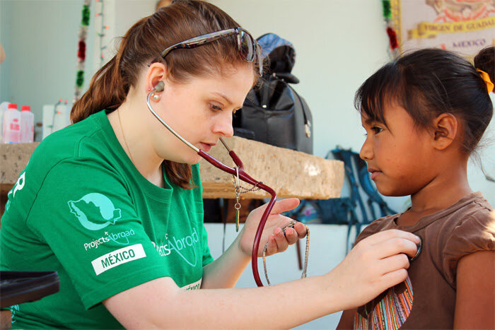 A Projects Abroad Public Health volunteer assists with a medical checkup in Mexico